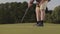 Unrecognized man playing golf hitting golf ball on the golf course. Summer leisure. Slow motion