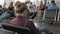 Unrecognized young female uses social networks on her smartphone while waiting for a flight while sitting in the airport
