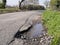 Unrepaired surface damage to tarmac on a rural road