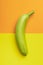 Unripe green banana on colorful background