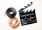 Unrolled 35mm movie reel and clapperboard in vintage color effect