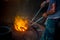 Unsafe worker hands. A local steel machine parts making yard worker melting scrap on hot furnace