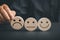 Unsatisfied customer holding frown icon on wooden circle