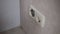 Unscrew the socket with a screwdriver. Electrician repairs the outlet.