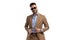 Unshaved handsome guy with sunglasses arranging suit