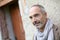 Unshaven senior man standing in front of old wall