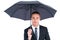 Unsmiling businessman sheltering under umbrella