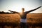 Unspecified man with hands up watching sunset