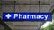 Unspecified universal Pharmacy neon sign above the entrance to a drug store