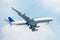 Unspecified white plane on the blue sky and white clouds.