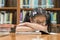 Unsuccessful educational system concept with Asian child girl student getting bored reading book in school classroom library