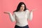 Unsure Plus Size Girl Shrugging Shoulders On Pink Studio Background