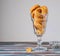 Unsweetened round cheese cookies with herbs and fried almonds in a glass glass on a wooden background. Savory cookie recipes as