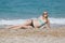 Untanned girl in bikini lying on side looking at camera