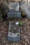 An untidy grave with a fallen flower pot on tombstone