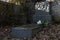 An untidy grave with a fallen flower pot on tombstone