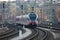 Untitled red passenger train arrival at railway train station. Platform track front view.