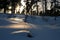 Untouched pristine snow with last rays of a sunset lighting a path