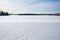 an untouched winter field with distant outdoor dance stage