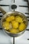 Untreated potatoes boil in a pot on a gas stove.