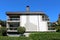 Unusual large suburban family house with partially stone tiles covered front facade and glass balconies on all sides