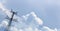 Unusual tilted composition of power lines and cloudscape on blue sky