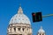 Unusual view of the dome of San Pietro in Rome with the red traffic light