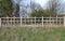Unusual wooden fence with parallel horizontal rails and vertical posts of different lengths in a pattern