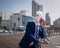 Unusual young man in elegant suit stands on the city waterfront