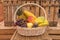 Unvarnished wicker basket filled with fresh fruits, bananas, mango, plums