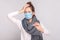 Unwell sick woman with surgical medical mask, scarf and have temperature, holding head and sad too looking thermometer with high