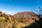 Unzen Nita Pass trail with rocky volcano peak, clear blue sky and colorful trees in Unzen-Amakusa National Park, Japan