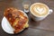 Ð¡up of cappuccino and fresh baked almond croissant.