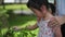 Up close Asian Chinese girl with mother teacher playing with plants nature outdoor