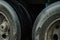 Up close to the tires of a cargo truck, black tires with dirt caused by rain in a city