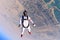 Up. Fly men is a pilot of his body in air. Extreme people prefer skydiving. Parachutist in white and orange suit. Free