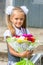 Up portrait of a seven-year school girl with bouquet of flowers