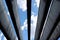 Up view to the blue sky with white clouds through parallel architectural concrete beams