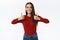 Upbeat, enthusiastic attractive brunette woman in red sweater approves your choice, showing thumbs-up and smiling