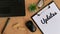 Updates word written on a piece of paper. With glasses, mouse, wooden blocks, plant, laptop and brown table background