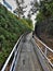 Uphill Concrete Sidewalk Walkway with Metal Railing and Greenery