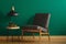 Upholstered chair by green wall