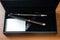 Upper close up case ball point fountain pens set lying on wooden desk. Blank card to write message as a gift. Excellent