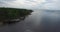 Upper flight along forestry bank of lake with rippling water