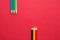 Upper and Lower Rows of Multicolored Pencils in Parallel Position Bottom and Top on Dark Red Paper Background. Business Creativity