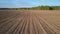 Upper motion from forest over ploughed field with residues