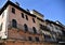 Upper part of the facades of ancient buildings, silhouetted against the blue sky, in Verona.