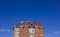 The upper part of a residential multi-storey new building against the blue sky