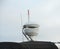 Upper part of a white luxury yacht with the navigational equipment on blue sky with clouds