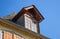 Upper storey with dove and nest outside. Facade of old wooden building. Birds and exterior of old house. Attic window with pigeon.